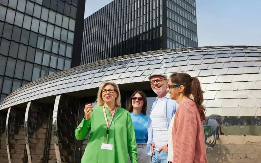 Group standing before curved modern building exterior